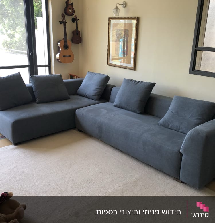 ספה אפורה עם כריות על שטיח בהיר